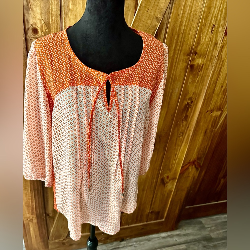 Flowy sheer orange and white blouse.